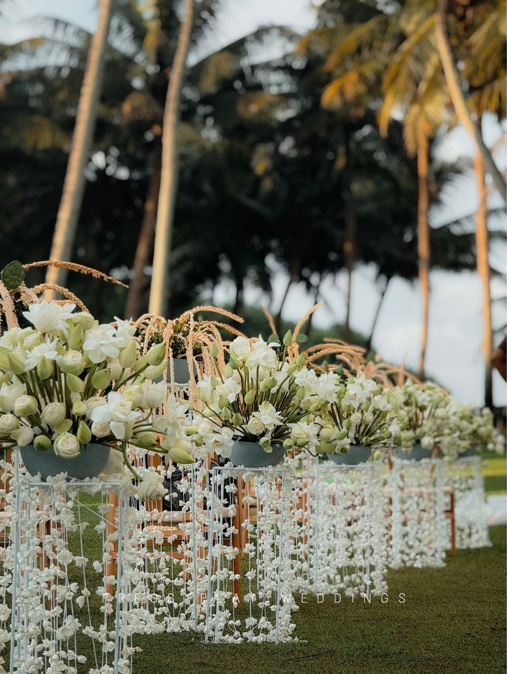 Lotus florals lining a palm-framed aisle