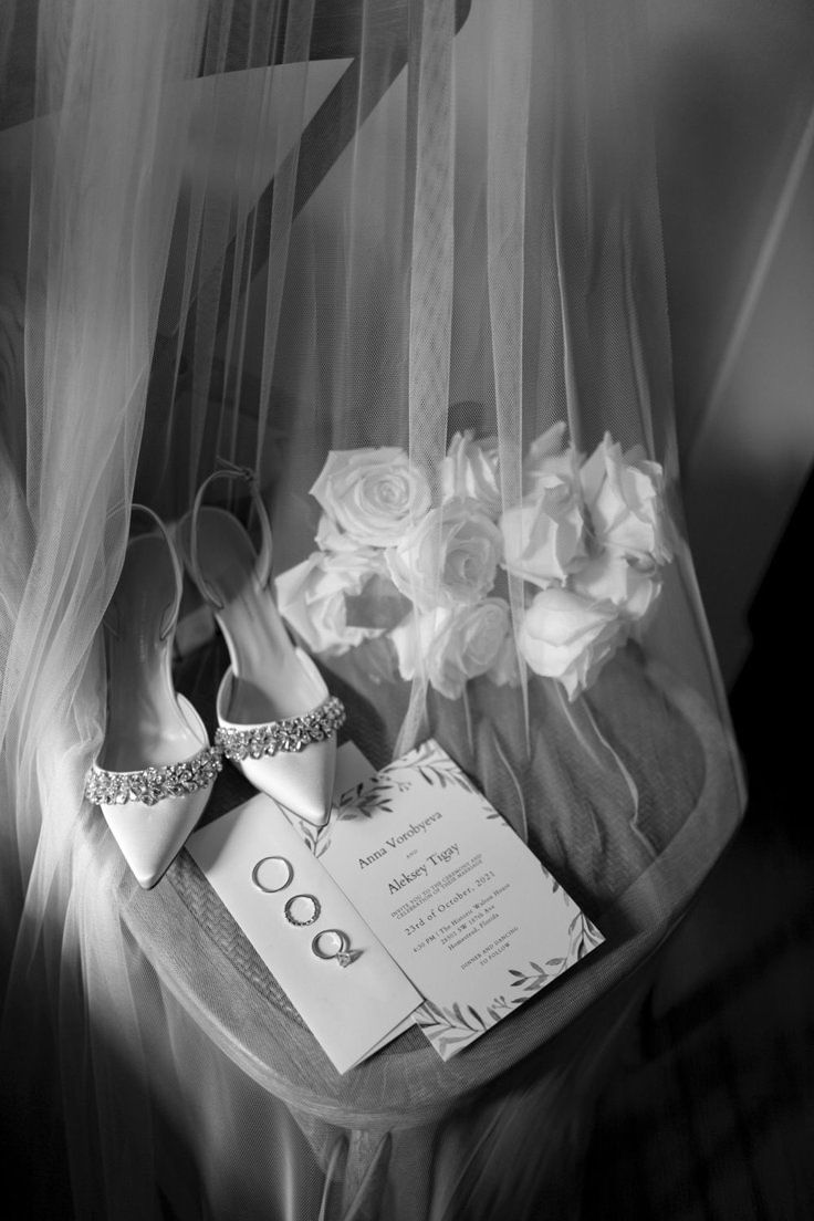 Bridal shoes, rings, and veil in monochrome
