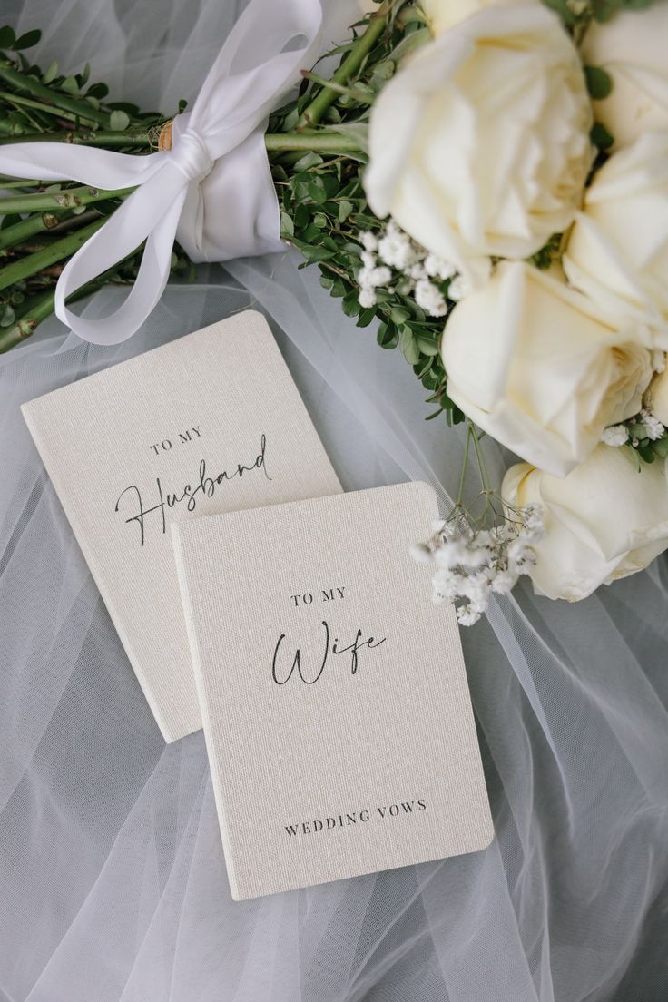 Vow books and white roses styled for an Abhises celebration